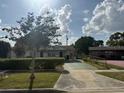 Charming single-story home featuring a well-maintained front yard with mature trees and a driveway at 4339 Solomon Dr, Orlando, FL 32811