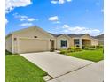 Well-maintained one-story home with a spacious driveway and lush green lawn in a peaceful neighborhood at 4492 Bluff Oak Loop, Kissimmee, FL 34746