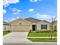 Beautifully landscaped one-story home with a two car garage, set against a bright blue sky with white clouds at 4492 Bluff Oak Loop, Kissimmee, FL 34746