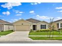 Inviting single-story home showcases a well-maintained lawn and a convenient two-car garage under a blue sky at 4492 Bluff Oak Loop, Kissimmee, FL 34746