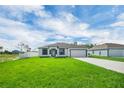 Inviting single-story home with lush green lawn, long driveway, and a two car garage at 4613 Madison Ave, Lake Wales, FL 33859