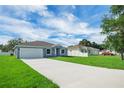 The front of the house showcasing a long driveway with green lawn space, and a blue sky at 4615 Madison Ave, Lake Wales, FL 33859