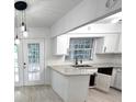 Bright kitchen with white cabinets, granite countertops, stainless steel sink and modern lighting at 5249 Se 106Th Ln, Belleview, FL 34420