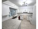 Modern kitchen with stainless steel appliances, granite countertops, and white cabinets at 5249 Se 106Th Ln, Belleview, FL 34420