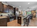 Eat-in kitchen featuring stainless steel appliances, a center island, and dark wood cabinetry at 551 Lasso Dr, Kissimmee, FL 34747