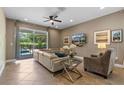 Cozy living room with neutral tones, a large sectional sofa, and access to the pool area at 551 Lasso Dr, Kissimmee, FL 34747