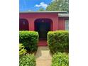 Inviting front entrance featuring a dark double door, archways, and well-manicured bushes at 6478 Inca St, Orlando, FL 32807