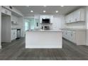 Bright kitchen featuring an island, stainless steel appliances, and white cabinets at 793 N Kentucky Ave, Umatilla, FL 32784