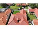 Aerial view of a red tile roof home with green grass, a white truck, and dark cars in the neighborhood at 8057 Marcella Dr, Orlando, FL 32836