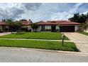 Attractive single-story home featuring a red tile roof and green lawn, exuding curb appeal at 8057 Marcella Dr, Orlando, FL 32836