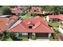 Charming single-story home featuring a red tile roof, an attached two-car garage, and lush landscaping at 8057 Marcella Dr, Orlando, FL 32836