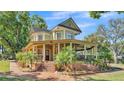 Charming two-story home with a large porch, brick steps, mature trees, and manicured landscaping at 822 W Patterson St, Lakeland, FL 33803
