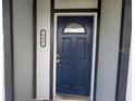 Close up of blue front door with oval window; a metal 946 is to its left at 946 Delano Ct, Kissimmee, FL 34758