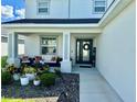 Inviting front porch features comfortable seating and a beautifully landscaped garden at 1016 Cascade Dr, Davenport, FL 33837