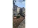 Tan two-story exterior with stairway, complemented by a mature palm tree and ground cover at 1023 S Hiawassee Rd # 4017, Orlando, FL 32835