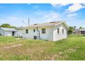 Rear view of a cozy home with a large, grassy backyard, showcasing the property's outdoor space at 120 & 0 8Th Wahneta W St, Winter Haven, FL 33880