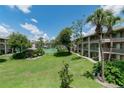 Scenic view of the condo community with large grassy area, mature trees, and tennis court in the background at 139 Oyster Bay Cir # 200, Altamonte Springs, FL 32701