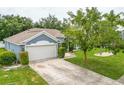 Aerial view of a well-maintained home with a spacious driveway and lush, green lawn at 157 Long Pine Dr, Deltona, FL 32725