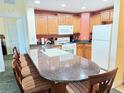 The kitchen features a large breakfast bar, wood cabinets, modern appliances, and stylish countertops at 1592 Heritage Crossing Ct # 202, Reunion, FL 34747