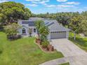 An aerial view of a landscaped single-Gathering home featuring mature trees and solar panels at 1631 Woodbay Ct, Kissimmee, FL 34744