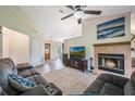 Cozy living room features a ceiling fan, fireplace, plush seating and seamless access to dining area at 1631 Woodbay Ct, Kissimmee, FL 34744