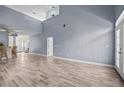 Spacious living room featuring high ceilings, light wood-look floors, and natural light streaming through the doorway at 1760 Saint Tropez Ct, Kissimmee, FL 34744