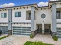 Modern townhouse with a two-car garage, balcony, and manicured landscaping at 1870 Brentwood Ct, Davenport, FL 33837