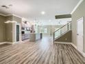 Open floor plan featuring modern stainless appliances and wood look floor with staircase at 1870 Brentwood Ct, Davenport, FL 33837