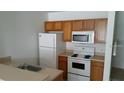 Functional kitchen with appliances including a white refrigerator, microwave, and stove at 2219 San Vittorino Cir # 106, Kissimmee, FL 34741