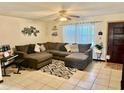 Cozy living room features a large sectional couch, tile floors, and a ceiling fan at 2266 Lake Lizzie Ct, St Cloud, FL 34771