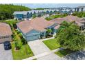 Beautiful aerial view of a single-Gathering home with a tile roof, landscaped yard, and paver driveway in a residential community at 2540 Swoop Cir, Kissimmee, FL 34741