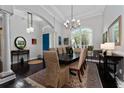 Elegant dining room with dark wood floors, a large window, a modern chandelier, and a stylish dining table at 2540 Swoop Cir, Kissimmee, FL 34741