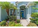Inviting front entrance with lush landscaping and a blue front door, showcasing a charming and well-maintained facade at 2540 Swoop Cir, Kissimmee, FL 34741