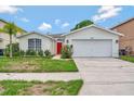 Charming one-story home with well-maintained lawn and a bright red front door, plus a two car garage at 307 Balmoral Ct, Davenport, FL 33896