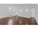 Bright living room featuring hardwood floors, neutral walls, and a classic entryway with arched window at 307 Balmoral Ct, Davenport, FL 33896