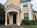 Close-up of peach siding and white trim with a black front door at 3301 Soho St # 104, Orlando, FL 32835