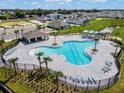 An aerial view of the community pool with clear blue water, cabana, and lounge chairs in a well-maintained space at 3886 Whitney Way, Haines City, FL 33844