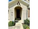 Inviting front entrance with an arched doorway, decorative elements, and manicured greenery at 4250 Roberta Dr, Winter Haven, FL 33881
