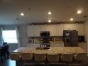 Open kitchen featuring an island with seating and stainless steel appliances for modern living at 621 Vittorio Dr, Winter Haven, FL 33884