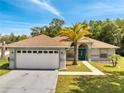 Attractive single-story home with a 2-car garage, stone walkway and mature palm tree at 640 Floridian Dr, Kissimmee, FL 34758