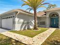 Close-up view of a single-story home with arched entryway and mosaic-tiled walkway at 640 Floridian Dr, Kissimmee, FL 34758