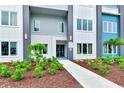 Close-up view of a three-story condo featuring a sidewalk, landscaping, and a sleek modern design at 7770 Sandy Ridge Dr # 142, Kissimmee, FL 34747