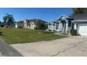 A street featuring similar homes with well-maintained lawns and landscaping in a suburban neighborhood at 852 Adour Dr, Kissimmee, FL 34759