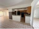 Open kitchen with wood cabinets, black appliances, and a breakfast bar perfect for casual dining and entertaining at 925 Derbyshire Dr, Kissimmee, FL 34758