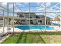 A view of the sparkling blue pool with screened enclosure and patio seating at 108 Honeywood Ct, Kissimmee, FL 34743