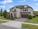 Charming two-story home with stone accents, a paver driveway, and a meticulously maintained lawn at 10950 Belle Maisons Dr, Orlando, FL 32832
