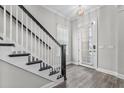 Inviting entryway with wood-look floors, staircase, and a window-paneled front door at 1379 Kiawah St, Celebration, FL 34747