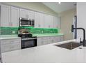 Bright kitchen featuring white cabinets, stainless steel appliances, quartz countertops, and a sleek, modern design at 14639 Musket Fire Ln, Orlando, FL 32837