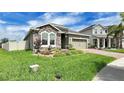 Charming home featuring a stone facade, manicured landscaping, and brick driveway, exuding curb appeal at 148 Whirlaway Dr, Davenport, FL 33837
