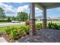 Inviting front porch with stone pillars, manicured landscaping, and a brick pathway at 15600 Vetta Dr, Bella Collina, FL 34756